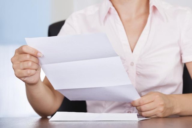A woman is reading her mail.