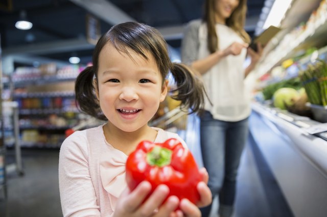 Portrait of smiling girl holding red bell pepper