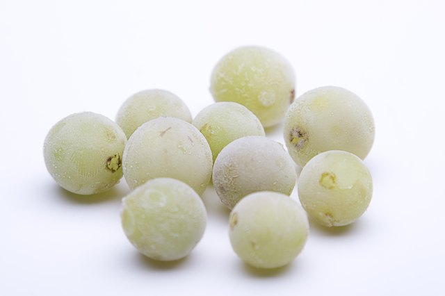 Frozen green grapes against white background