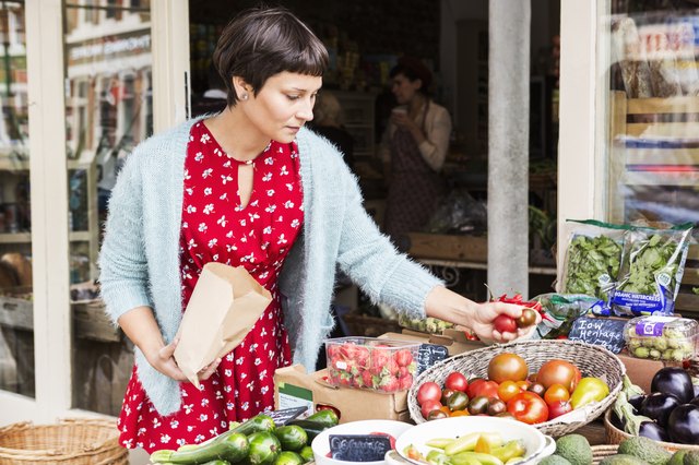 Woman selecting tomatoes at local farm shop.