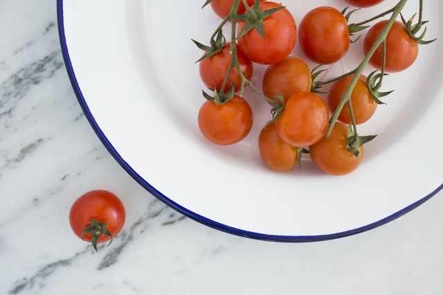 Tomatoes in a white enamel bowl on white marble