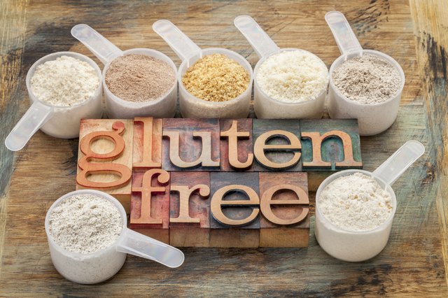 measuring scoops of gluten free flours (almond, coconut, teff, flaxseed meal, whole rice, brown rice, buckwheat) wit a text in letterpress wood type