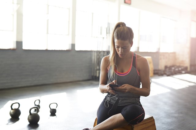 Woman tjecking results on smartphone at gym