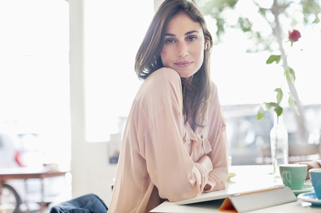 Portrait of confident woman with digital tablet in cafe