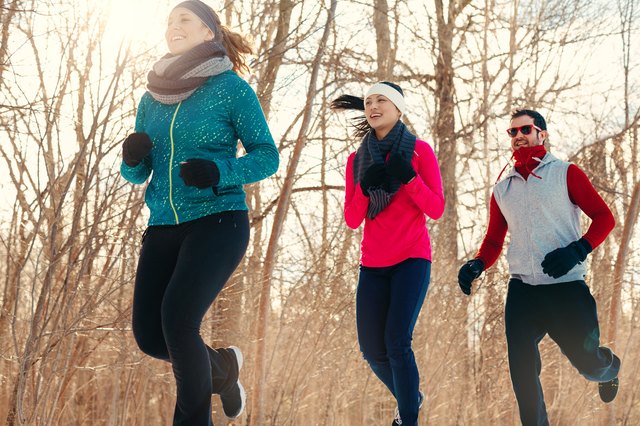 Group of friends enjoying jogging in the snow in winter