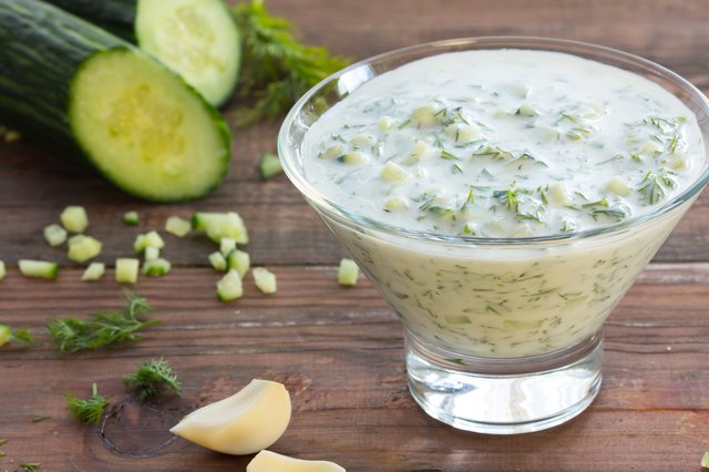 Traditional greek sauce Tzatziki and ingredients. Yogurt, herbs, garlic cucumber