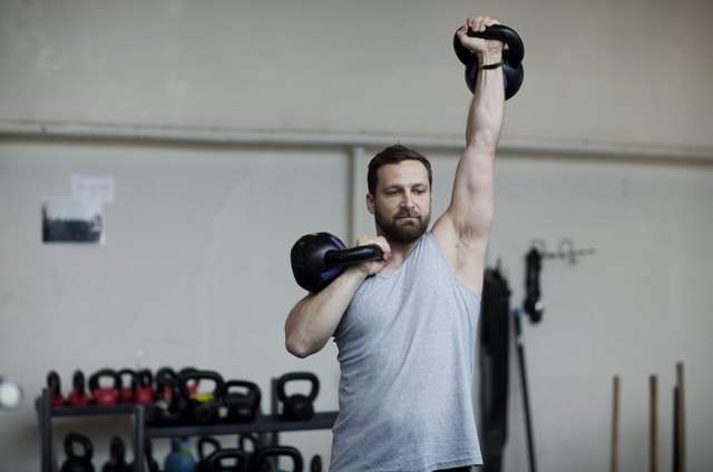 man training with kettlebells in gym