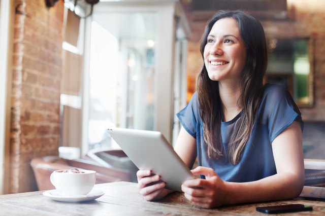 Woman using digital tablet in cafe.