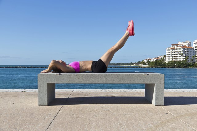 Hispanic woman doing leg raises for fitness