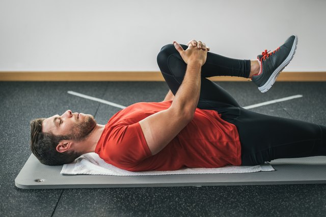 healthy man stretching leg before gym workout