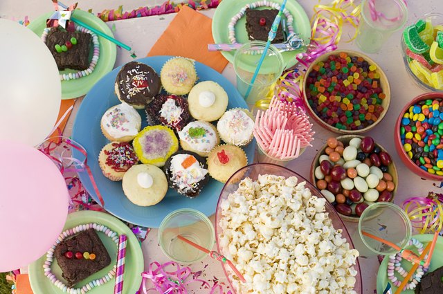 Party table with cupcakes, popcorn, and candies