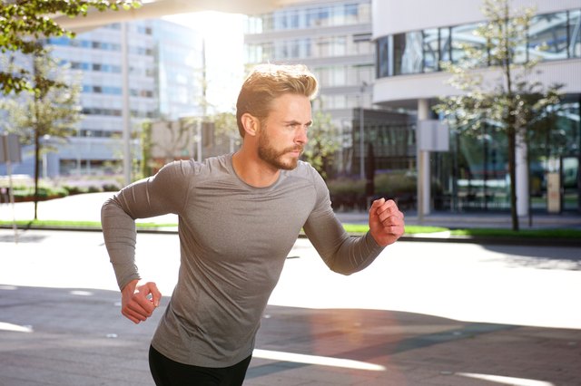 Active sports man running outside in the city