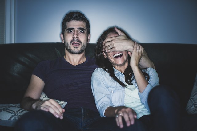 Couple watching thriller on sofa