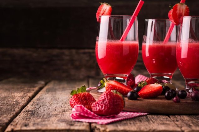 Glasses of fresh cold smoothie with fruit and berries, on wooden background, healthy detox drink