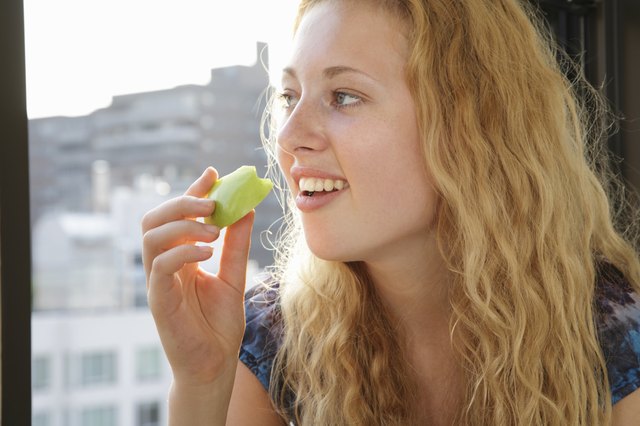 Young woman holding a slice of apple