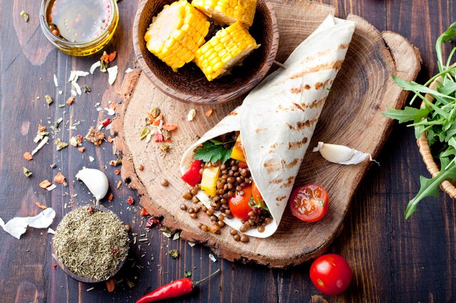 Vegan tortilla wrap, roll with grilled vegetabes, lentil, corn cob.