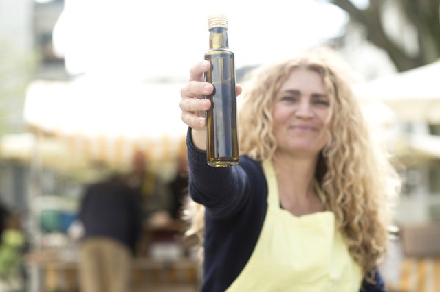 Market trader with bottle of olive oil