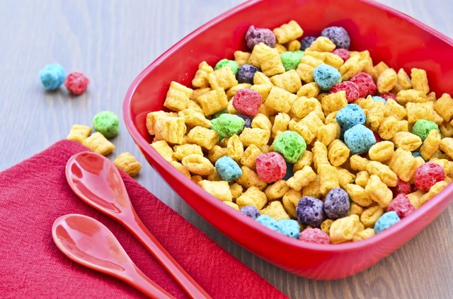 Bowl of corn and oat cereal and two spoons on a wooden table