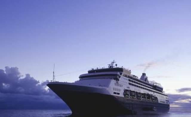A cruise ship sails the ocean at dusk.