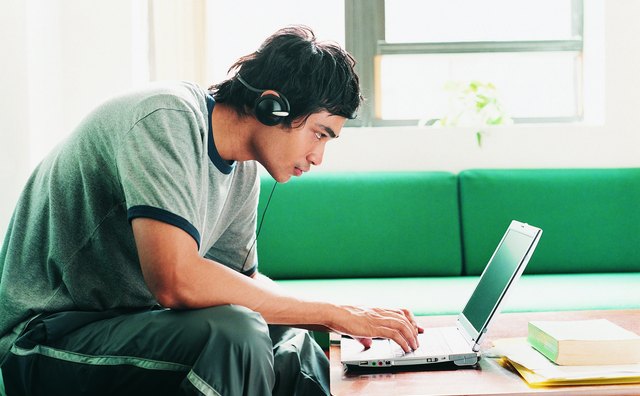 Asian Student Using Laptop at Home