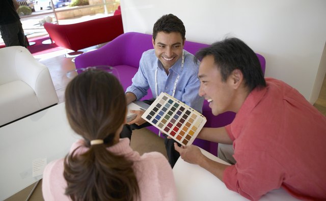 Couple With a Shop Assistant in a Furniture Shop Looking at a Colour Swatch