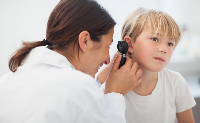 Doctor auscultating the ear of a child