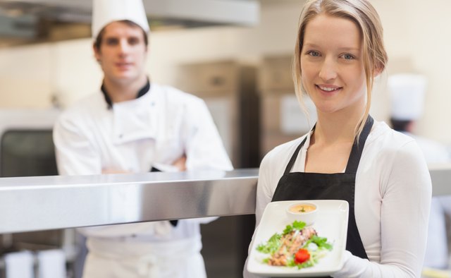 Smiling waitress carrying salmon plate