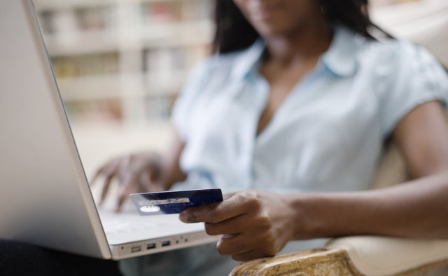 Woman Using Credit Card and Laptop