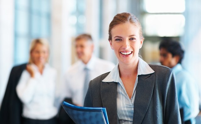Happy businesswoman with colleagues in the background