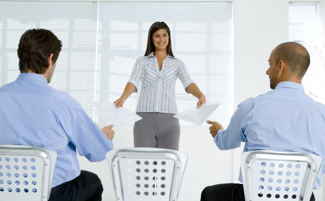 Businesswoman handing papers to businessmen