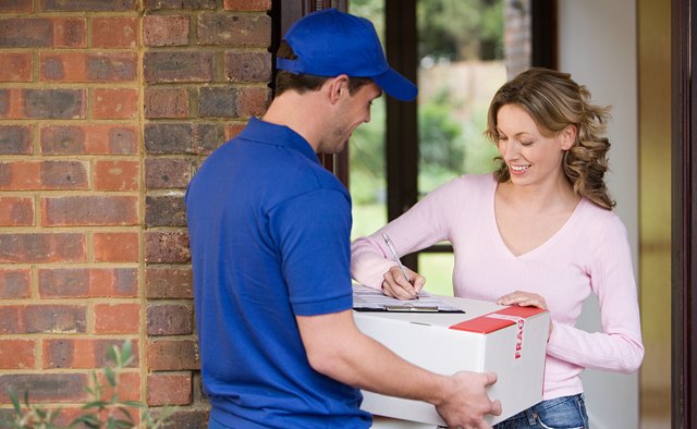 Woman getting a parcel from delivery man
