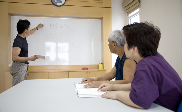 Couple watching man writing on white board