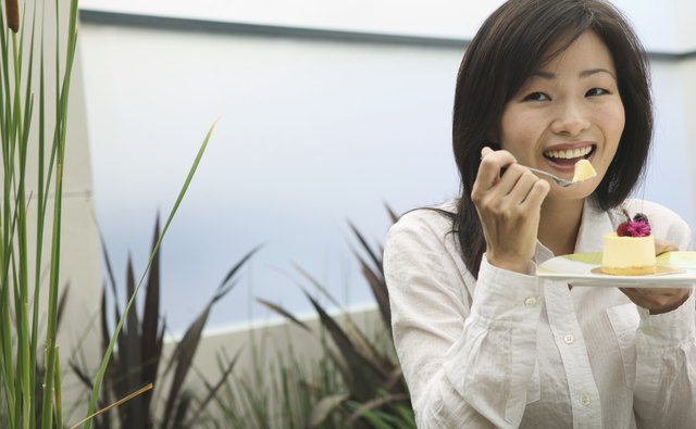 Portrait of a young woman eating from a plate with a fork