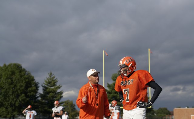 Teenage (16-17) American football player talking with coach