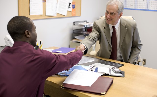 Businessmen shaking hands in office