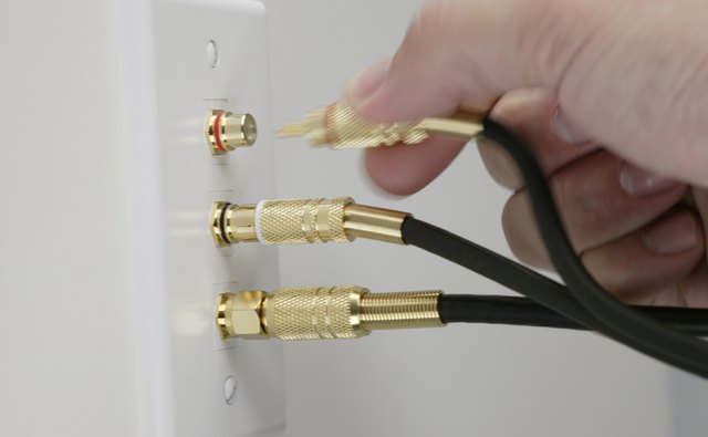 Person plugging cables into an electrical outlet