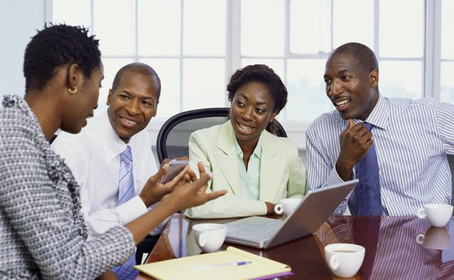 two businessmen and two businesswomen discussing in an office