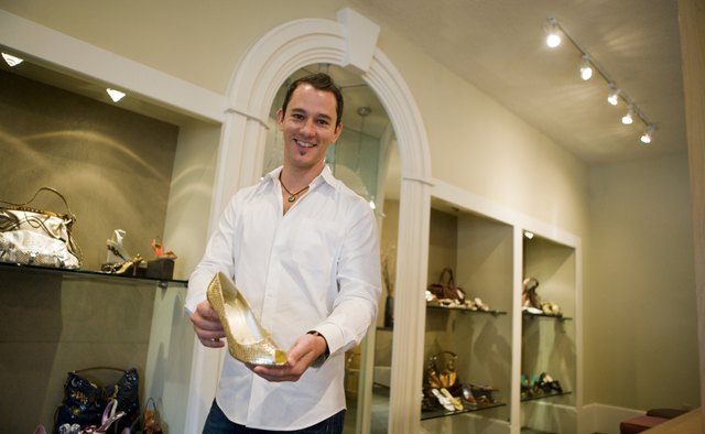 Portrait of a mid adult man showing woman's shoe in a store