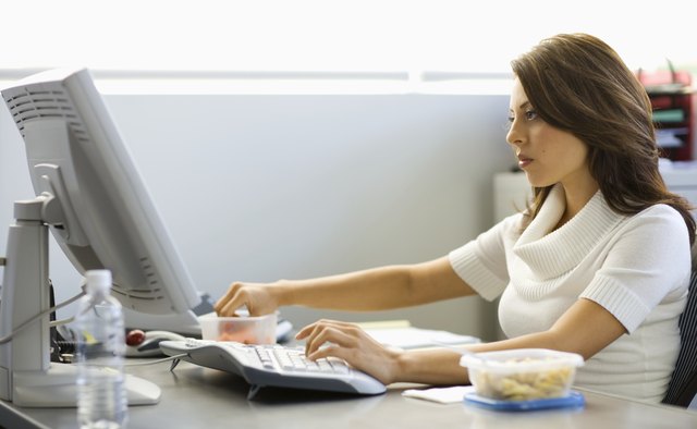 Young businesswoman eating lunch at desk