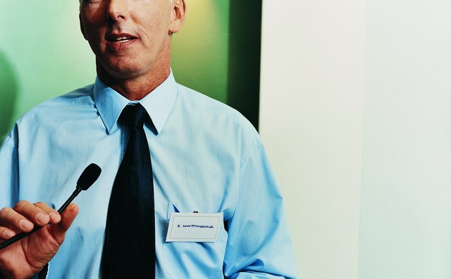 Portrait of a Businessman Giving a Presentation at a Podium and Holding a Microphone