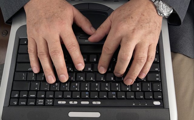 Businessman's hands on laptop computer keyboard, close-up