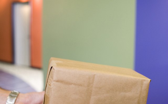 Close-up of the hands of two people holding a box