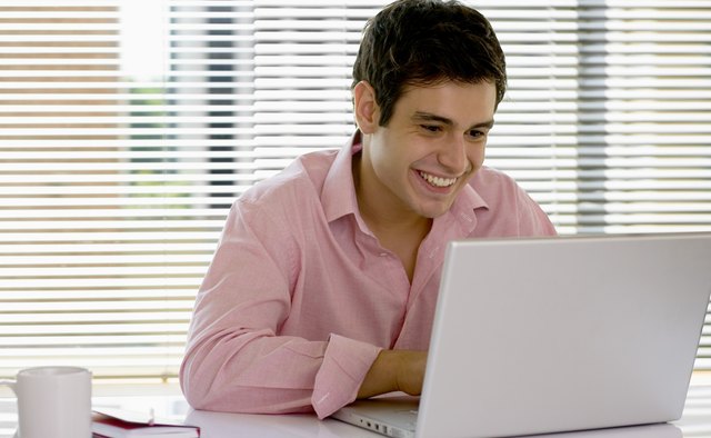 Smiling businessman using laptop