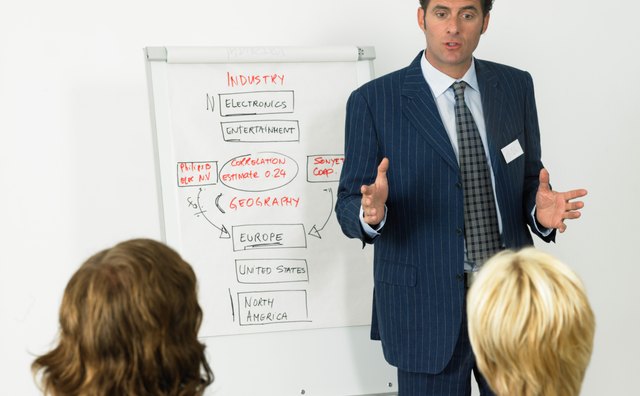 Businessman giving presentation, colleagues in foreground