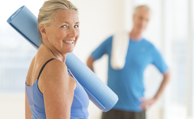 Smiling Woman With Exercise Mat At Home