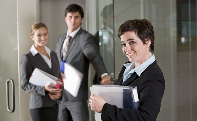 Three office workers at door of boardroom