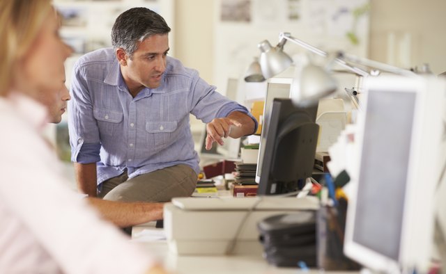 Workers At Desks In Busy Creative Office