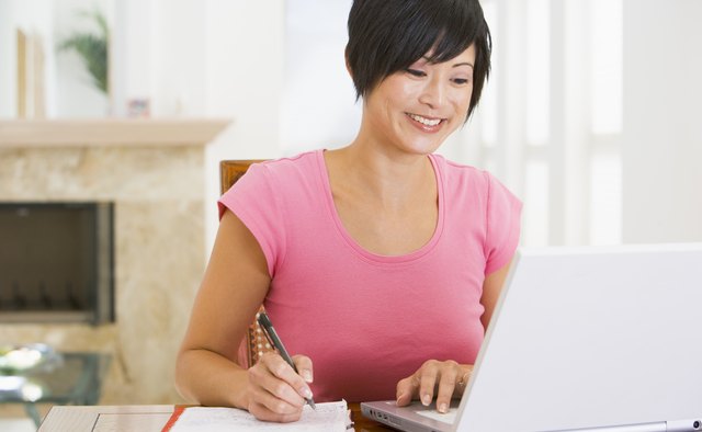Woman in dining room with laptop smiling