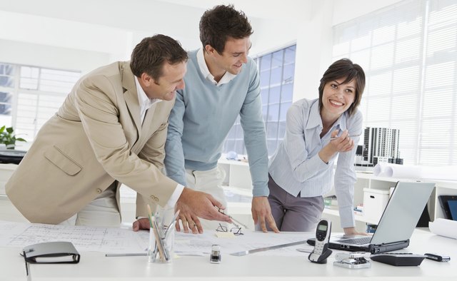 Architects with blueprints and laptop