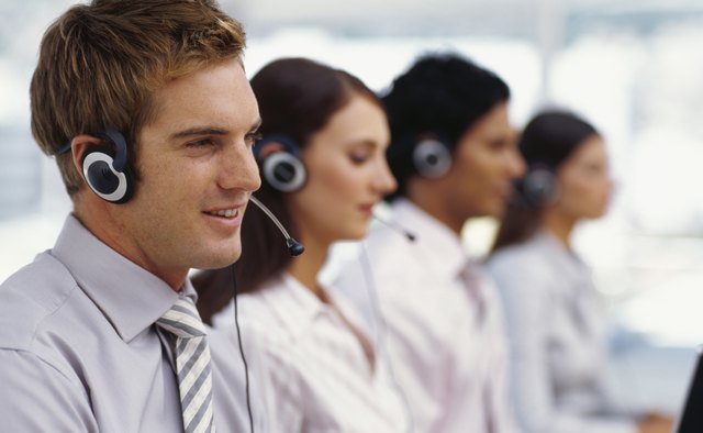 side profile of four business executives wearing headsets in an office